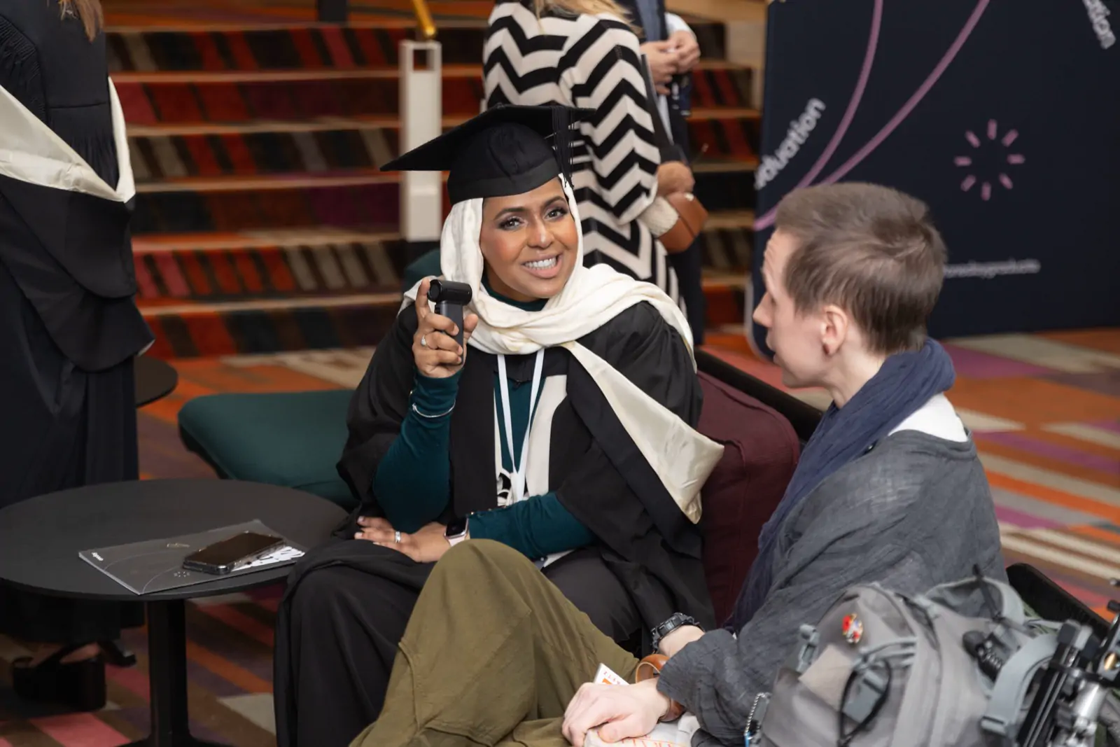 Ines Abdalla laughing mid-conversation with another graduate